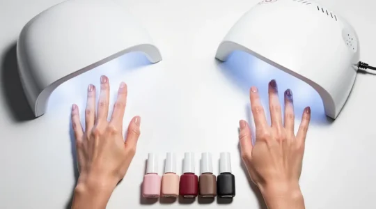Professional nail lamp setup with gel polish bottles and cured nails showing the comparison between LED and UV curing technologies