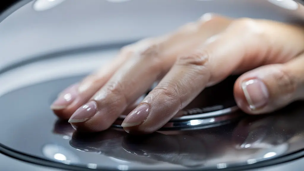 Close-up view showing thumb positioning challenges in nail lamp with visible light distribution patterns