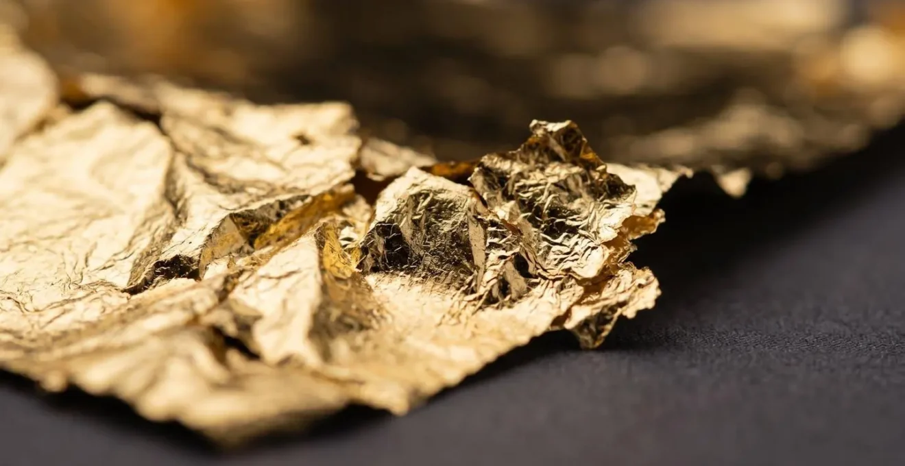 Extreme close-up of genuine gold leaf showing intricate texture and light interaction