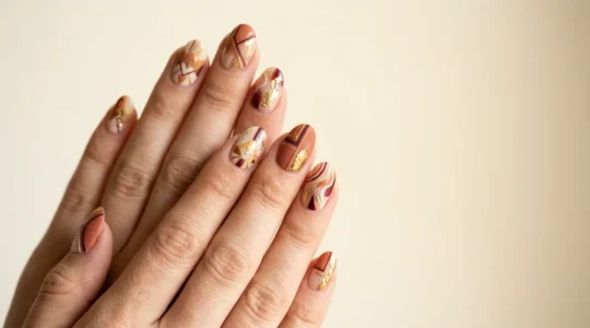 Close-up of hands displaying maximalist layered pattern nail art with mixed textures and cohesive color palette