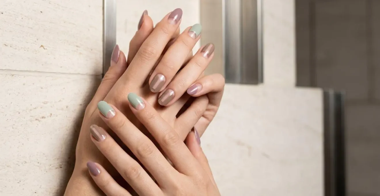 Elegant hands displaying negative space nail art with geometric transparent sections on almond-shaped nails